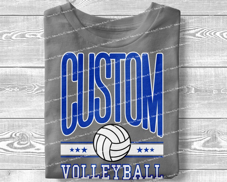 May include: Grey t-shirt with the text "CUSTOM VOLLEYBALL" in blue and white lettering. A white volleyball with black stitching is centred above the text.