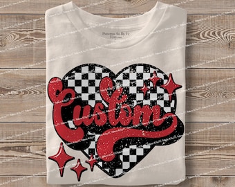 May include: A cream-coloured t-shirt with a heart-shaped design. The heart features a black and white chequered pattern, with the word "Custom" in red, retro lettering. Red starbursts complete the vintage design.