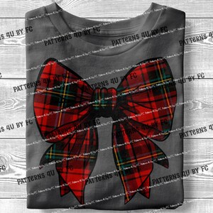 May include: A red and green plaid bow with a yellow and white trim. The bow is on a gray background.