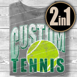 Puede incluir: Camiseta gris con las palabras "CUSTOM TENNIS" en una fuente verde y blanca desgastada, con un gr&aacute;fico de pelota de tenis. Un c&iacute;rculo negro y dorado con el texto "2 en 1" est&aacute; en la esquina superior derecha.
