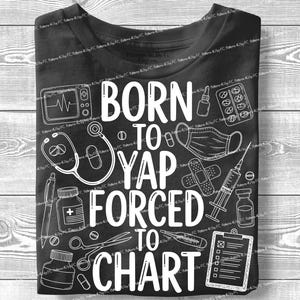 Puede incluir: Camiseta negra con ilustraciones médicas blancas y el texto "BORN TO YAP FORCED TO CHART." El diseño incluye un estetoscopio, pastillas, una jeringa y una historia clínica.