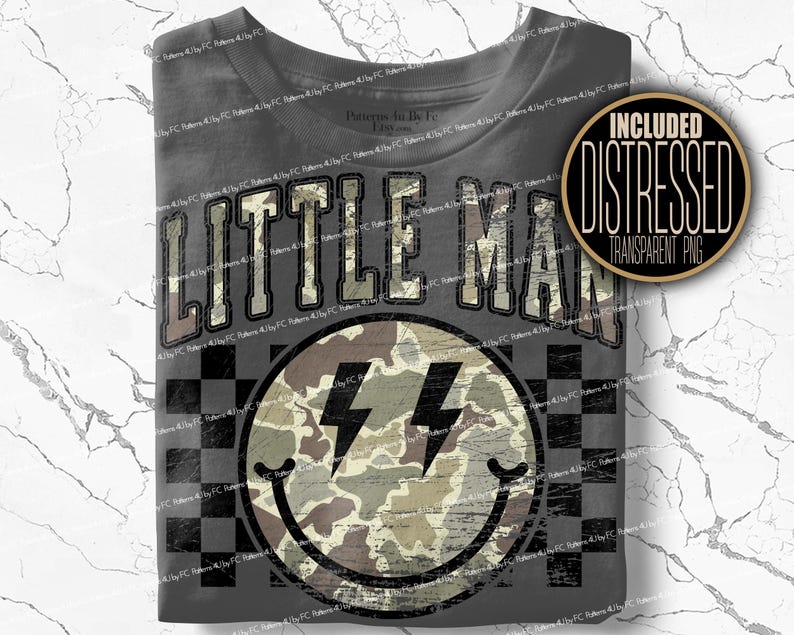 K&ouml;nnte beinhalten: Graues T-Shirt mit dem Text "LITTLE MAN" in einer verblassten Schriftart im College-Stil. Darunter befindet sich ein Smiley mit Blitzaugen und einem Camouflage-Muster. Das Shirt hat ein Schachbrettmuster.
