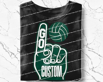 Könnte beinhalten: Schwarzes T-Shirt mit einem Design einer grünen und weißen Schaumstoffhand. Der Zeigefinger trägt die Aufschrift "GO", und die Basis "CUSTOM". Ein grüner und weißer Volleyball befindet sich über der Hand. Das T-Shirt ist gefaltet.