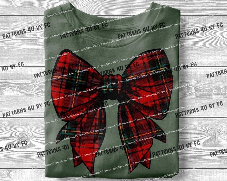 May include: A green t-shirt with a red and black plaid bow on the front. The bow is tied in a knot and has a large, flowing loop.