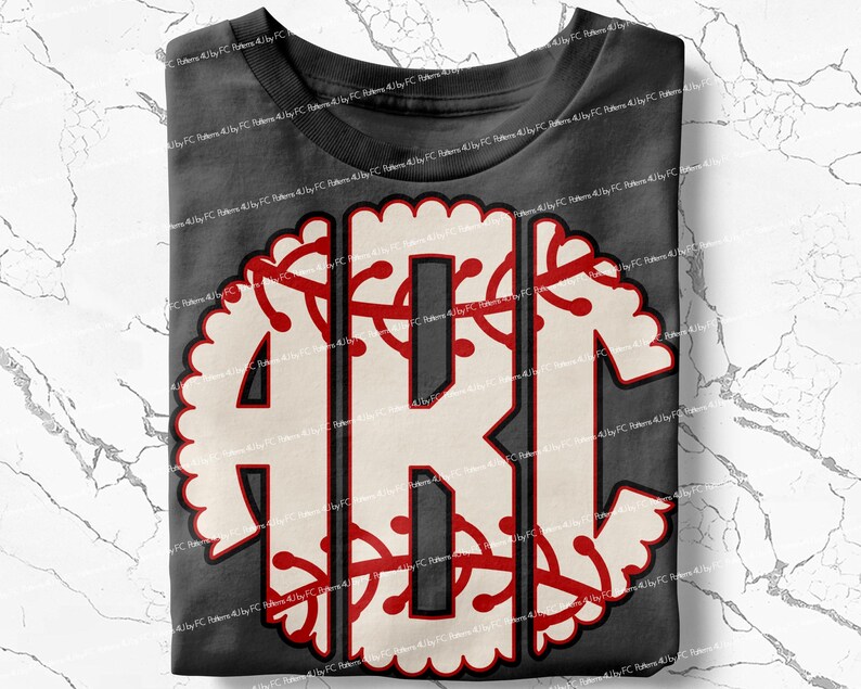 May include: A gray t-shirt with a white and red monogram design. The monogram is in the shape of a baseball with a scalloped edge.
