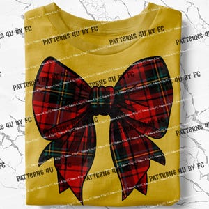 May include: A yellow t-shirt with a large red and black plaid bow on the front. The bow is tied in a knot and has a long, flowing tail.