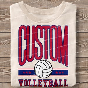 May include: A white t-shirt with a red and blue design that says "CUSTOM VOLLEYBALL" with a volleyball graphic in the centre.