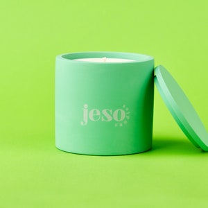 May include: A green candle with a white lid and the word "jeso" printed on the side.