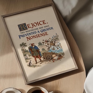 Può includere: Una stampa incorniciata con un'illustrazione in stile medievale di una persona con mantello blu e tunica rossa accanto a un carro rotto e un gatto. Il testo recita: REJOICE. THIS MISFORTUNE MAY HAVE PREVENTED A GREATER NONSENSE.