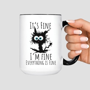 May include: White ceramic mug with a black rim and handle. The mug features a distressed black cat illustration with the text "IT'S FINE I'M FINE EVERYTHING IS FINE" in black font.