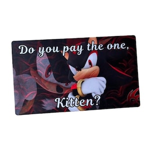May include: Rectangular card featuring a cartoon character with black fur, red eyes, and white gloves. The card has the text "Do you pay the one, Kitten?" in white script. The background is a dark, blurred image.