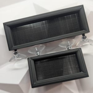 May include: Two black plastic vent covers with mesh inserts and suction cups. The vent covers are rectangular and have a black frame around the mesh.