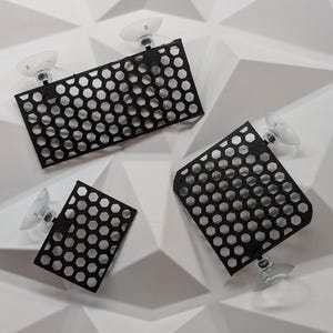 May include: Three black plastic mesh panels with suction cups. The panels are designed to be attached to a smooth surface.
