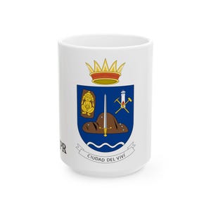 May include: White ceramic mug featuring the Ciudad del Vivi coat of arms. The design includes a gold crown, a shield with a figure, sword, and tools, and the text "Ciudad del Vivi" on a banner. The letters "PR" are printed on the side.