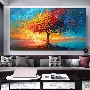 May include: A painting of a tree with red, yellow, and blue leaves. The tree is silhouetted against a sunset sky with a body of water in the foreground.
