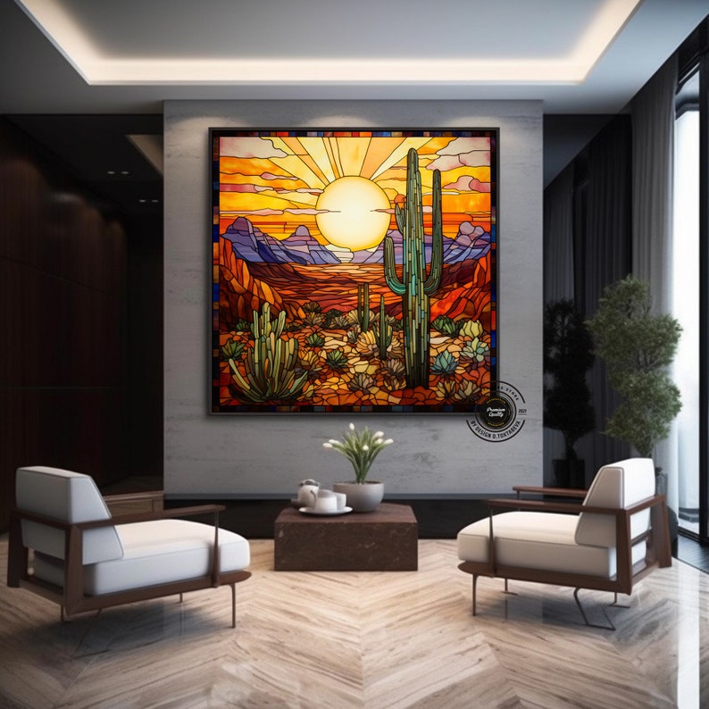 May include: A stained glass artwork depicting a desert landscape with a large saguaro cactus in the foreground. The sun is setting behind the mountains, casting a warm glow over the scene. The artwork is framed in a black frame.