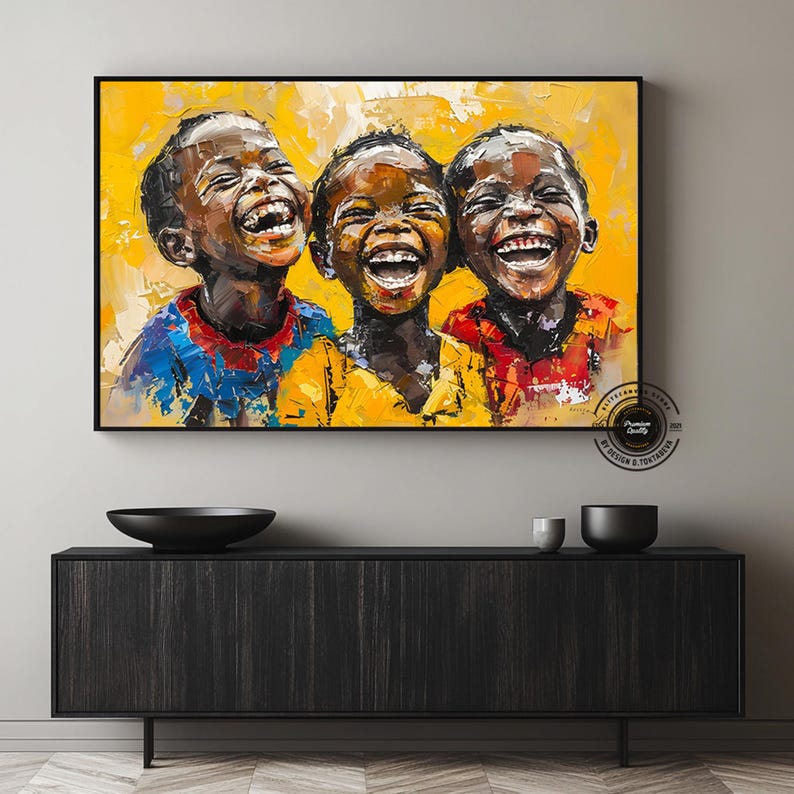 Pu&ograve; includere: Stampa artistica incorniciata con un dipinto a olio di tre bambini che ridono. I bambini, con la pelle scura, indossano camicie colorate su uno sfondo giallo. L'opera d'arte &egrave; esposta sopra un mobile in legno scuro.