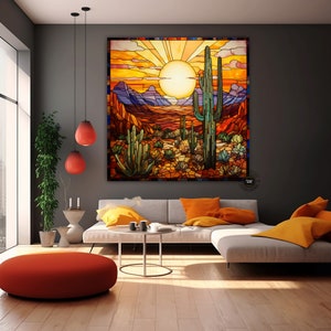 May include: A stained glass style artwork depicting a desert landscape with a large cactus in the foreground. The sun is setting behind the cactus, casting a warm glow on the scene. The artwork is framed and hanging on a wall in a living room.