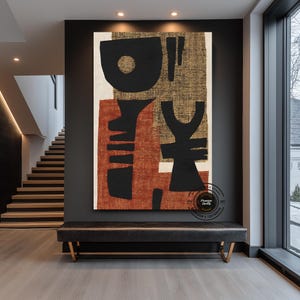 May include: Large abstract canvas art with black, rust, and gold shapes. The artwork hangs above a black leather bench with gold legs in a modern entryway. The art features a mix of geometric and organic forms.