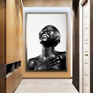 Op de afbeelding: Zwart-wit portret van een persoon die lacht met zijn hoofd naar achteren gekanteld. De persoon is topless en heeft zijn handen voor zijn borst gevouwen.