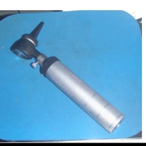 May include: A silver and black otoscope with a black ear speculum. The otoscope is used to examine the ear canal.