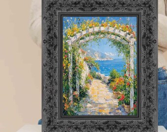 Può includere: Dipinto incorniciato raffigurante una scena costiera con un arco bianco fiorito, che conduce a un sentiero che si affaccia sul mare blu. La cornice è grigio scuro con un design ornamentale in rilievo. L'opera presenta colori vivaci.