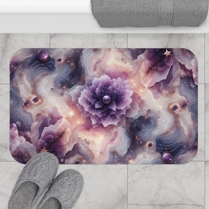 May include: Purple and gold abstract bath mat with a large flower in the center. The flower has a pearl-like center and is surrounded by swirling patterns.