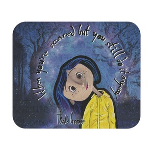 May include: A rectangular mousepad with an illustration of a girl with blue hair and a yellow jacket. The text "When you're scared but you still do it anyway. That's brave" is written around the girl.
