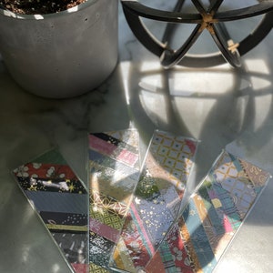 May include: Four colorful bookmarks with a variety of patterns and designs. The bookmarks are made of paper and are laminated with a clear plastic coating. The bookmarks are arranged in a fan shape.
