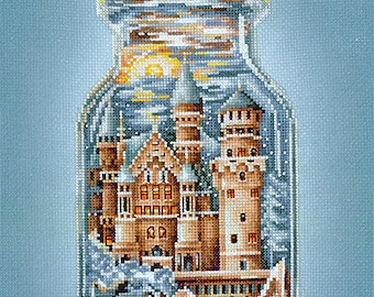 May include: A glass jar with a cork lid contains a miniature castle with a red roof and white trim. The castle is surrounded by a blue and white sky and clouds. The jar is on a light blue background.