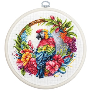 May include: A colourful parrot cross-stitch pattern with tropical flowers and leaves in a circular frame. The parrot is red, blue, green, and yellow. The flowers are pink, orange, and yellow.