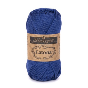 Könnte beinhalten: Ein Knäuel blaue Wolle mit einem braunen Papieretikett. Das Etikett zeigt den Markennamen "Scheepjes" und das Wort "Catona". Das Garn ist fest gewickelt und hat ein weiches Aussehen. Geeignet zum Stricken und Häkeln.