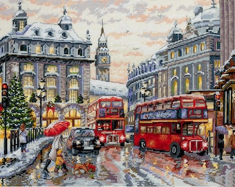May include: A snowy London street scene with red double-decker buses, a Christmas tree, and a clock tower in the background.