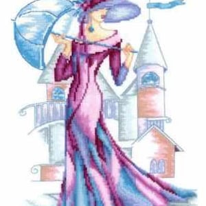 May include: Cross-stitch design of a woman in a long, flowing gown and hat, holding a parasol. The dress is pink, purple, and blue, with a matching hat. The background features a building with towers and a blue flag.