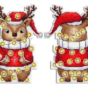 Könnte beinhalten: Zwei Kreuzstichmuster eines Rentiers, das einen roten Weihnachtsmann-Hut und einen roten Pullover mit einem Schneeflockenmuster trägt. Das Rentier ist mit einer Lichterkette aus gelben Lichtern verziert.