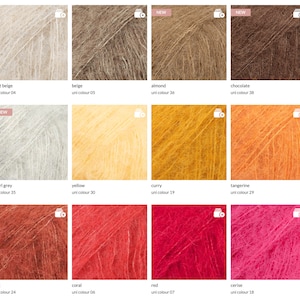 May include: A color chart of yarn samples in various shades of white, gray, yellow, orange, red, and pink. The yarn is a soft, fuzzy mohair blend.