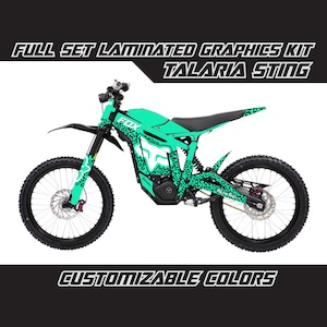 Op de afbeelding: Volle set gelamineerde graphics kit voor een Talaria Sting elektrische dirt bike. De graphics hebben een teal en zwart luipaardprint ontwerp met het woord "FOX" aan de zijkant. Aanpasbare kleuren.
