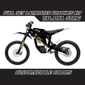 May include: Full set of laminated graphics for a black and gold electric dirt bike. The graphics feature the words "Rockstar Energy Drink" and "Surron" in gold lettering. The bike is a Surron Talaria Sting.