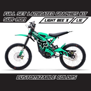 May include: A green and black graphic kit for a Sur-Ron Light Bee X electric motorcycle. The kit features a Fox Racing logo and the text "LIE".