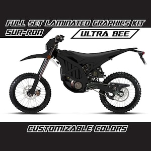 May include: Full set of laminated graphics kit for a Sur-Ron electric motorcycle. The kit features a black and white design with the words "Ultra Bee" and "Customizable Colors".