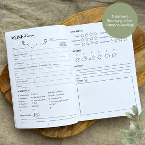 May include: A black and white camping trip log book with a checklist of amenities, a section for notes, and a place to rate the campsite. The book has the title "Meine Reise" on the cover.