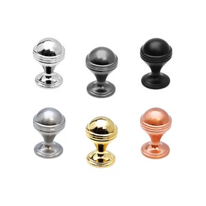 May include: Six cabinet knobs in different finishes: polished chrome, nickel, black, brass, and copper. Each knob has a round top with a raised ring and a flared base.