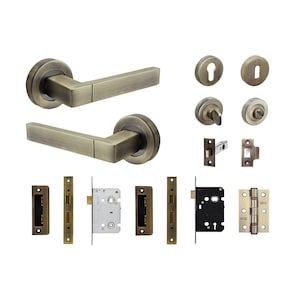 May include: A set of antique brass door hardware, including two door handles, two door knobs, two door latches, two strike plates, a door lock, and a pair of hinges.