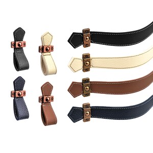 May include: Set of eight leather cabinet pulls in four colours: black, cream, brown, and navy blue. Each pull features a pointed end, a stitched seam, and a decorative metal accent.