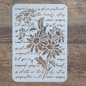 Könnte beinhalten: Eine weiße Gänseblümchen-Schablone mit Schrifttext. Die Schablone zeigt ein Gänseblümchen-Blumenmuster mit mehreren Blüten und Blättern. Der Text enthält Sätze wie "the bamly astr" und "sompaseta".
