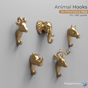 Puede incluir: Cinco ganchos dorados con forma de cabeza de animal para colgar objetos. Los ganchos tienen forma de carnero, elefante, caballo, rinoceronte y ciervo. Los ganchos son imprimibles en 3D y están disponibles en los formatos STL, OBJ y gcode. El texto "Animal Hooks" y "3D Printable File" se muestra encima de los ganchos. El texto ".STL .OBJ .gcode" se muestra debajo de los ganchos. El texto "PolygonWays" se muestra en la esquina inferior derecha de la imagen.