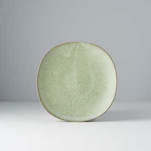 Könnte beinhalten: Runder, hellgrüner Keramikteller mit gesprenkelter Textur und braunem Rand. Der Teller hat eine leicht unregelmäßige Form. Geeignet zum Servieren von Speisen, misst er etwa 25 cm im Durchmesser.