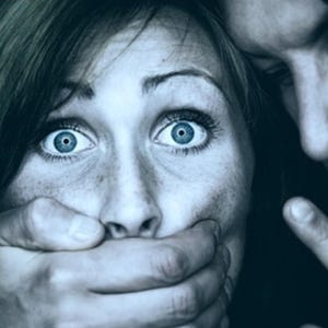 Może przedstawiać: Zbliżenie osoby z szeroko otwartymi, niebieskimi oczami i dłonią zakrywającą usta. Widoczna jest dłoń i twarz innej osoby, z palcem wskazującym na osobę. Obraz ma mroczny, ponury ton.