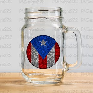 May include: A clear glass mason jar mug with a handle. The mug has a round sticker on the front featuring the Puerto Rican flag with a white, blue, and red color scheme. The flag has a white star in the blue triangle.