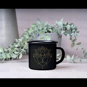 Puede incluir: Taza de esmalte negro con un dise&ntilde;o de flor de loto dorada. La taza tiene un asa y un borde negros. La flor de loto es una ilustraci&oacute;n detallada con l&iacute;neas delicadas y un patr&oacute;n sim&eacute;trico.